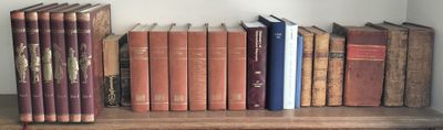 de nombreux livres qui se trouvent sur une étagère dans la pièce