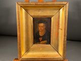 an old picture of a man in a black shirt is on a wooden easel