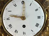 a gold clock with roman numerals on the face