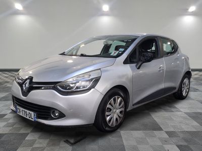 une voiture argentée est garée dans une pièce au sol en damier