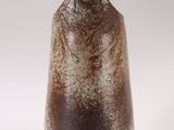 a brown vase that is sitting on a white surface