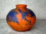 un vase orange et bleu posé sur une table