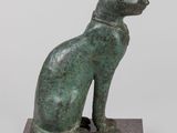 statue of a cat sitting on a base on a white background