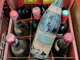 plusieurs bouteilles de vin dans un carton posé sur le sol