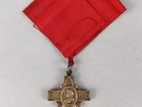 an image of a medal with a cross on a red ribbon
