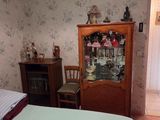 a bed and a cabinet in a room with a floral wallpaper