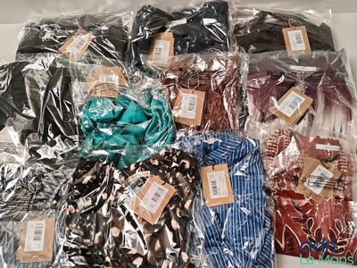 many different colored shirts wrapped in plastic bags on a table