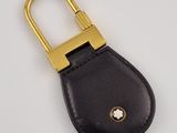 a black leather key case with a gold metal clasp