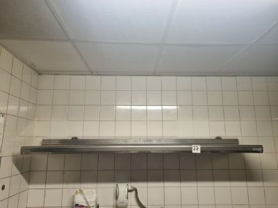 a metal shelf above a sink in a bathroom