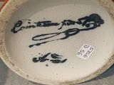 a white bowl with black writing on it sitting on a table