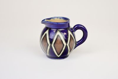 pichet en céramique violet et blanc, orné d'un motif géométrique sur l'extérieur