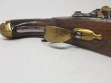 a close up of a rifle with a brass plated handle and brass fittings