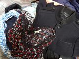 a pile of clothes that is sitting on a bed
