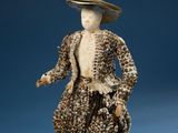 a figurine of a woman in a dress and hat