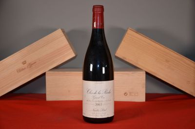 a bottle of wine sitting on a table next to two wooden boxes