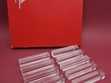 a set of four clear acrylic coasters with a red box