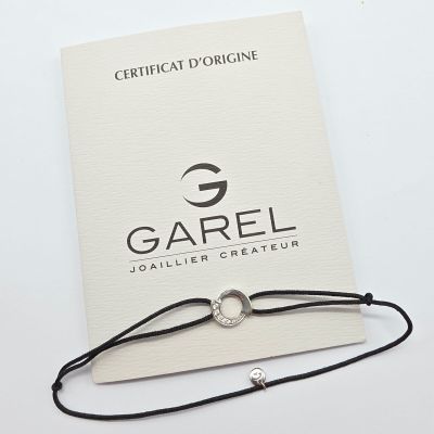 le bracelet est présenté sur une carte portant le nom de l'entreprise