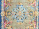 a blue and yellow rug with a floral design on it