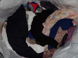 a bag full of clothes that is sitting on the floor
