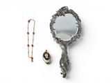 a mirror and a necklace on a white surface
