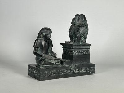 statue d'une femme assise sur un socle, avec un oiseau sur la tête
