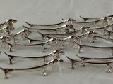 twelve silver plated trays on a white surface with a white background