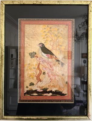 framed picture of a bird on a branch with a woman in the background