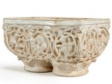 a white bowl with carvings on it on a white surface