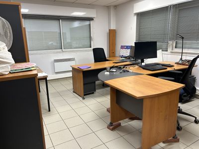a room with a desk, chair, and a fan in it