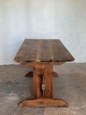 une image représentant une table en bois posée sur un sol en béton
