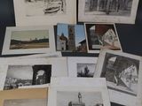 plusieurs vieilles photographies en noir et blanc représentant des bâtiments, posées sur une table