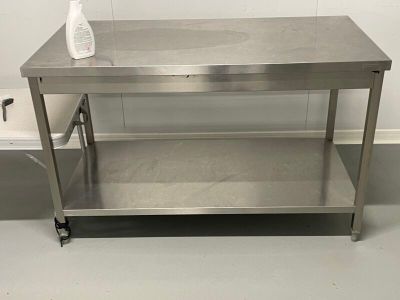 a stainless steel table with a bottle of liquid on it