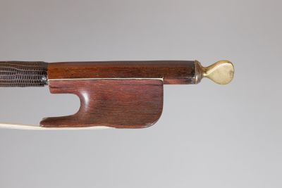 une image représentant un archet de violon muni d'un manche en bois sur fond blanc