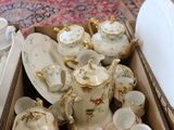 a box full of tea cups and saucers sitting on the floor
