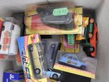 a cardboard box filled with toy cars and other items