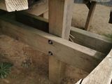 a close up of a wooden table with a bench in the background