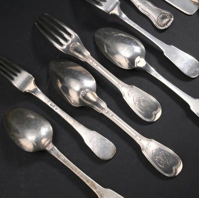 six cuillères et une fourchette sur une table noire