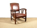 un fauteuil en cuir marron posé sur un sol recouvert de moquette