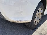 a white car that has been damaged and is sitting in the parking lot