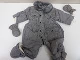 a baby boy ' s outfit and mittens laying on a table