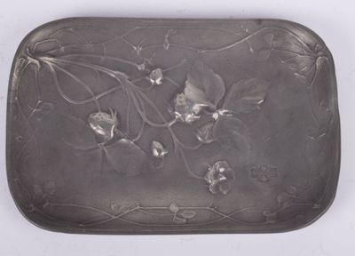 assiette en argent décorée de fleurs et de feuilles sur un fond blanc