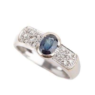 a close up of a diamond and sapphire ring on a white background