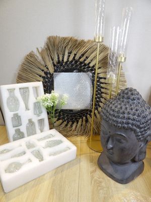 une statue représentant une personne assise à côté d'une boîte de glaçons posée sur une table