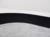 a close up of a black leather belt on a bed