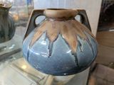 un vase bleu et marron exposé dans une vitrine