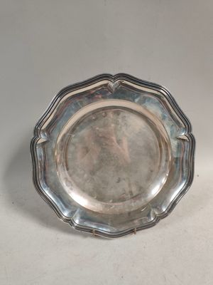 une assiette en argent posée sur une table, sur fond blanc