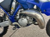 a blue and white dirt bike parked in a parking lot
