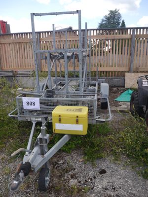 a small trailer with a yellow box attached to it