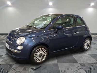 la photo d'une petite voiture bleue sur un sol en damier