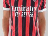 Le jeune homme porte un t-shirt rayé rouge et noir.